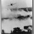 Two bombs tumble from a Vietnamese Air Force A - 1E Skyraider over a burning [Viet] Cong hideout near Cantho, South Viet Nam, 1967. Library of Congress, EUA.